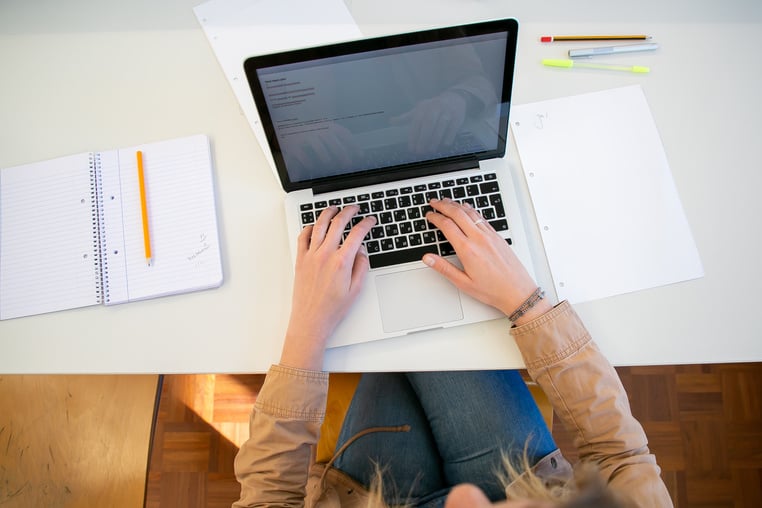 Woman working on laptop with documents